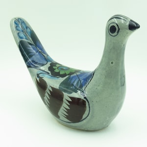 May include: A hand-painted ceramic dove figurine with blue, green, and brown floral designs on a gray background.