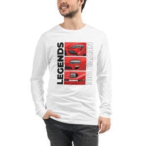 Puede incluir: Camiseta blanca de manga larga con tres ilustraciones rojas de la parte delantera de un coche. La camiseta tiene el texto "LEGENDS" en negro a la izquierda y "NEVER DIE" en blanco a la derecha.