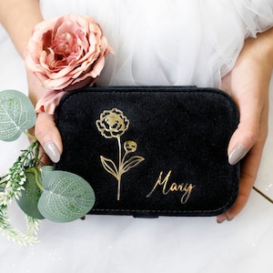 May include: Black velvet jewelry box with a gold floral design and the name "Mary" inscribed on the front.