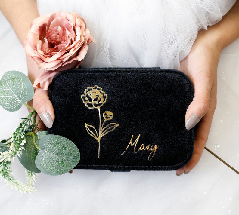 May include: Black velvet jewelry box with a gold floral design and the name "Mary" inscribed on the front.