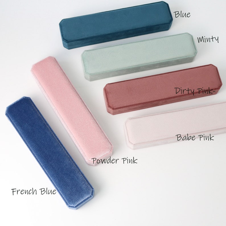 May include: Five velvet jewelry boxes in different colors: French Blue, Powder Pink, Babe Pink, Dirty Pink, and Minty. The boxes are lined with soft velvet and have a rectangular shape.