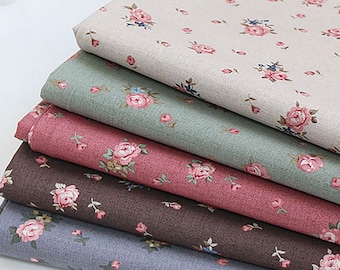 May include: A stack of five fabric swatches with a floral pattern. The swatches are in various shades of brown, pink, green, and gray. The floral pattern is a small, delicate rose.