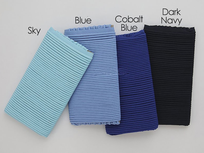 May include: Four samples of ribbed fabric in different shades of blue: sky blue, blue, cobalt blue, and dark navy.