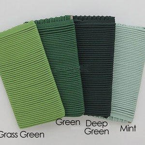 May include: Four fabric swatches in different shades of green. From left to right: grass green, green, deep green, and mint.
