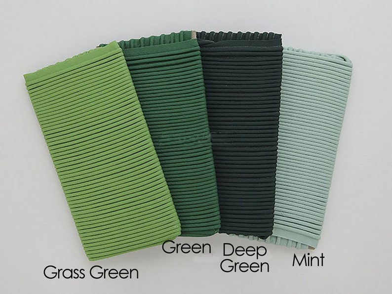 May include: Four fabric swatches in different shades of green. From left to right: grass green, green, deep green, and mint.