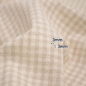 May include: Close-up of a beige fabric with a white gingham pattern. The fabric has a 3mm x 3mm grid pattern.