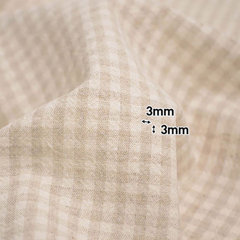 May include: Close-up of a beige fabric with a white gingham pattern. The fabric has a 3mm x 3mm grid pattern.