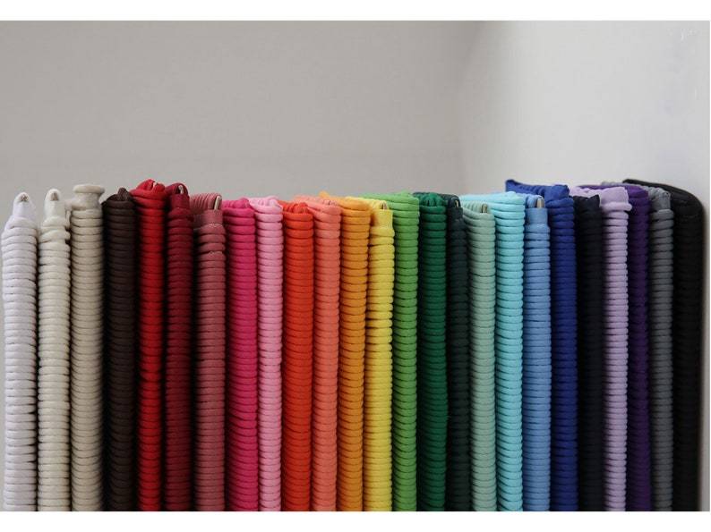 May include: A collection of colorful fabric rolls, arranged in a rainbow pattern. The rolls are made of a soft, textured material and are perfect for crafting projects.