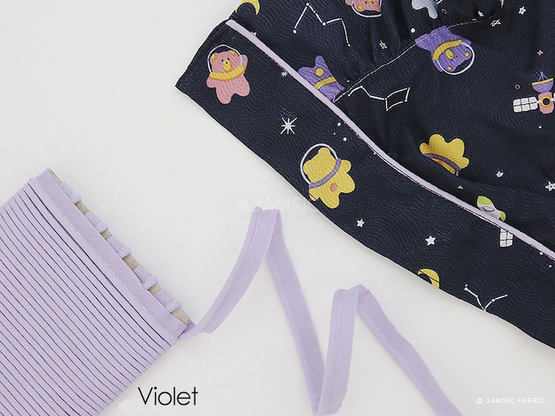May include: A close-up of a purple fabric trim with a textured surface. The trim is folded and arranged in a wavy pattern. The word "Violet" is printed in black below the trim.