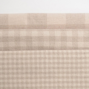May include: Three layers of beige gingham fabric with a subtle texture. The fabric is folded in thirds, creating a layered effect.