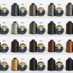 Puede incluir: Un conjunto de 20 carretes de hilo en varios colores, incluyendo gris, marr&oacute;n, verde y beige. Cada carrete est&aacute; etiquetado con un n&uacute;mero, como "CO81" y "CO96".