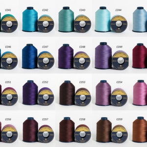 Puede incluir: Una colecci&oacute;n de 20 carretes de hilo en varios colores, incluyendo turquesa, azul, morado, burdeos y marr&oacute;n. Cada carrete est&aacute; etiquetado con un n&uacute;mero, como C041, C042, etc. Los carretes est&aacute;n dispuestos en cuatro filas de cinco carretes cada una.