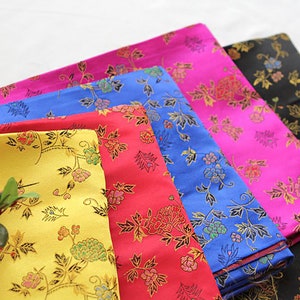 May include: Five fabric swatches with floral patterns in different colors: yellow, red, blue, pink, and black. The fabric has a subtle sheen and a delicate floral design.