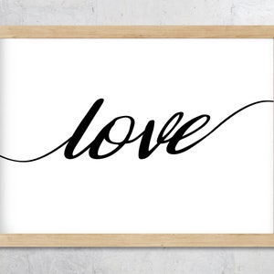 May include: A framed print featuring the word "love" in black cursive script against a white backdrop. The artwork is presented within a light-coloured wooden frame, ideal for interior decoration.