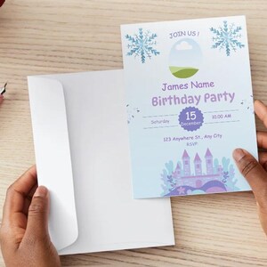 Pode incluir: Um convite de anivers&aacute;rio com um envelope branco. O cart&atilde;o de convite tem um fundo azul claro com ilustra&ccedil;&otilde;es de flocos de neve e castelo. O texto inclui "James Name Birthday Party" e informa&ccedil;&otilde;es de data.
