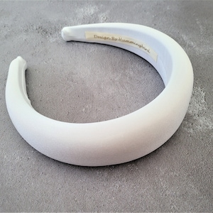May include: White padded headband with the text "Design By Hummingbird" on the inside.