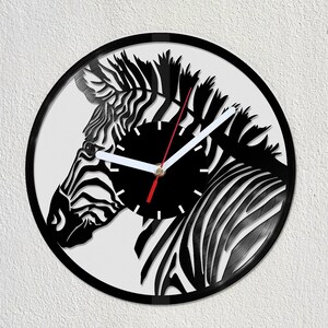 May include: Black and white vinyl record clock featuring a zebra design. The clock hands are white and red.