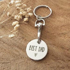 May include: Silver keychain with a round tag that says "Best Dad" with a heart symbol.