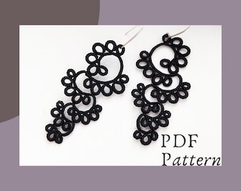 Pode incluir: Um par de brincos de crochê preto com um design delicado e intrincado. Os brincos estão pendurados em ganchos prateados. A imagem inclui o texto "PDF Pattern".