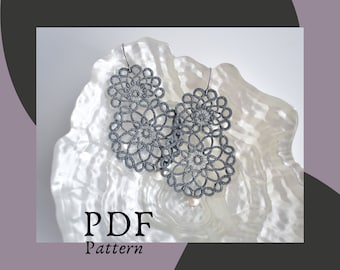 May include: A pair of gray crocheted earrings with a pearl accent. The earrings are displayed on a white background with the text "PDF Pattern".
