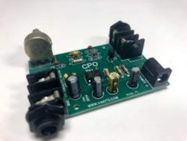 May include: A green circuit board with a potentiometer, two 1/4 inch jacks, and a power jack. The board has the text "CPO" printed on it. The board is for a guitar effects pedal.
