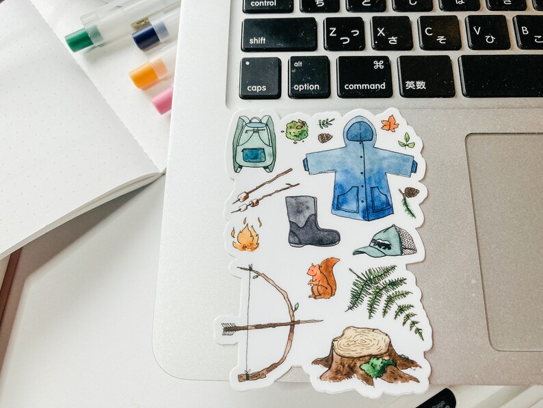 K&ouml;nnte beinhalten: Eine Sammlung von Aquarell-Aufklebern mit Camping- und Outdoor-Motiven. Enth&auml;lt einen blauen Rucksack, einen blauen Regenmantel, ein Lagerfeuer, Pfeil und Bogen, ein Eichh&ouml;rnchen, einen Stiefel, eine M&uuml;tze und einen Baumstumpf.