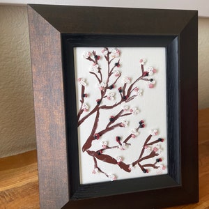 Quilled cherry blossom tree. Framed in 8x10 table top frame (see pictures). Perfect for first anniversary gift of paper. Use in any room!