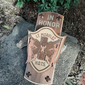 May include: A wooden plaque with the words "In Honor" and "Lt. Morales" engraved on it. The plaque also features a stylized medical star with the letters "H.O.T.S." below it.
