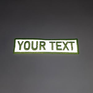 A rectangular patch with the text "YOUR TEXT" printed on it in green.