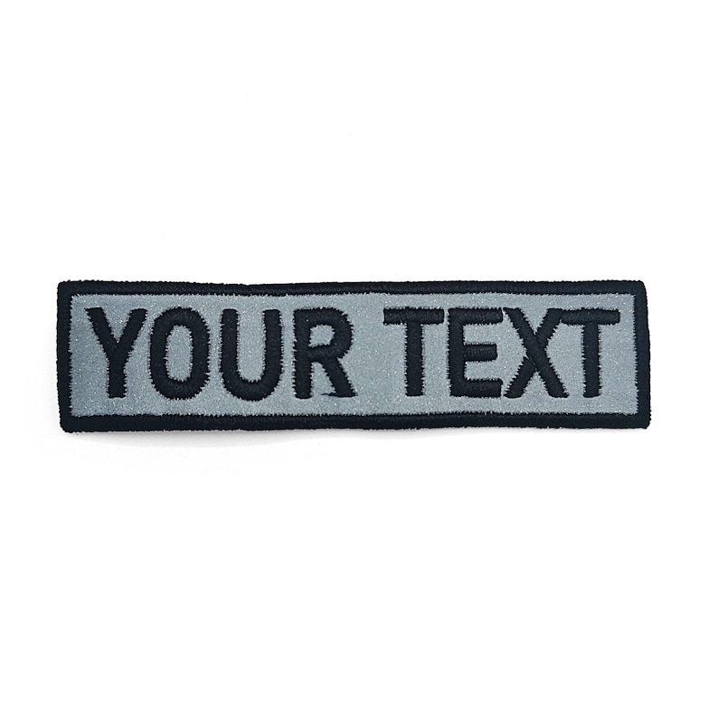 A gray rectangular patch with the text "YOUR TEXT" printed on it.