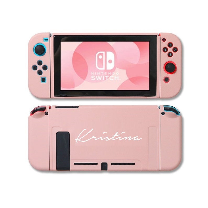 May include: A pink Nintendo Switch console with a white custom design that says "Kristina".