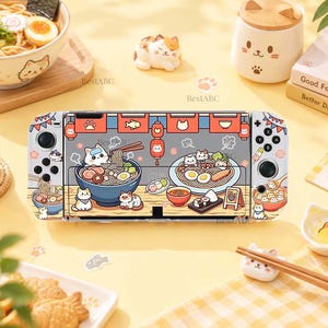 May include: A handheld gaming console featuring a custom skin with a colorful illustration of cats eating ramen, sushi, and dumplings. The design includes red banners with cat icons, various bowls of food, and small cat characters on a light background.
