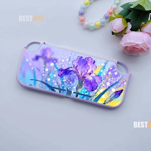 May include: A rectangular protective case for a handheld gaming console featuring a vibrant purple iris flower illustration against a blue and yellow background with sparkling white light effects and cutouts for buttons and joysticks.