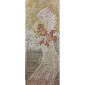 Op de afbeelding: Een schilderij van een engel met witte vleugels en een witte jurk. De engel heeft blond haar en kijkt omhoog. De achtergrond is lichtgeel.