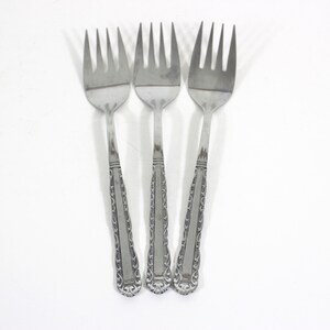 May include: Three silver forks with ornate handles.