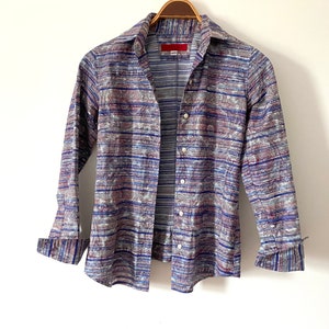 May include: A long-sleeved button-down shirt with a blue, gray, and red striped pattern. The shirt has a classic collar and a button-up front.