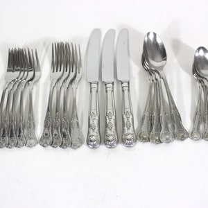 May include: A set of stainless steel cutlery, comprising forks, knives, and spoons, displayed on a white background. The silverware has decorative handles with a floral pattern. The spoons and knives have a polished, reflective finish.