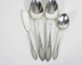 May include: Four pieces of silverware, including a butter knife, two spoons, and a smaller spoon. The silverware is silver-plated and has a decorative design on the handles.