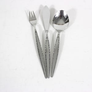 以下が含まれることがあります： 装飾的なハンドルが付いた銀色の食器3点セット。セットにはフォーク、ナイフ、スプーンが含まれています。