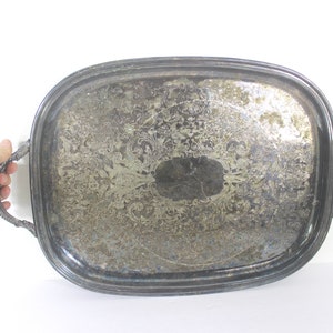 May include: A silver serving tray with ornate embossed designs and two twisted wire handles.
