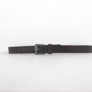 May include: A brown leather belt with a silver buckle.