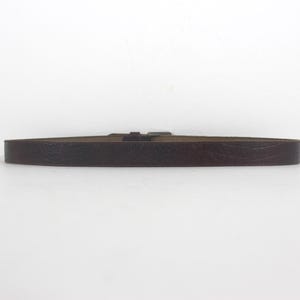 May include: A brown leather belt with a silver buckle.