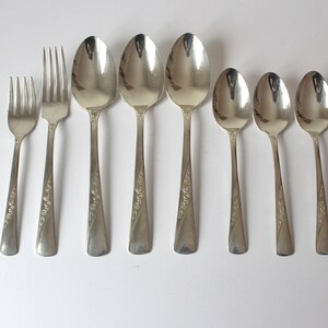 May include: Set of eight silver-plated spoons and forks with an engraved floral design and the text "Thank You" on the handle.