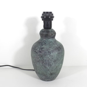May include: A green ceramic table lamp with a black cord and a black socket.