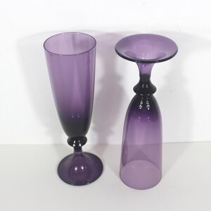May include: Two purple glass goblets, one tall and slender, the other shorter and wider, with a flared top.
