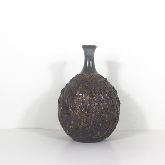 A signed, heavily textured MCM stoneware bud vase — the kind of blue-green-brown glazed piece that serious shelf-stylers hunt vintage markets for.