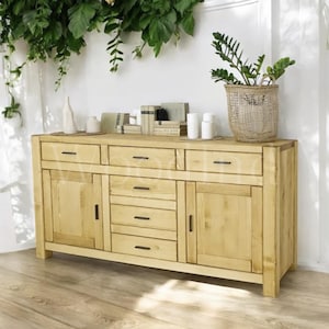 May include: A light wood sideboard with two doors and six drawers. The sideboard has black metal handles and sits on a light wood floor.