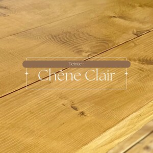 May include: Close-up of a light-colored wooden surface with visible grain and knots. The text "Teinte : Ch&ecirc;ne Clair" is displayed in a rectangular frame, indicating the color or finish of the wood.