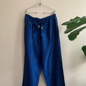 May include: A pair of blue satin pants with a drawstring waist.