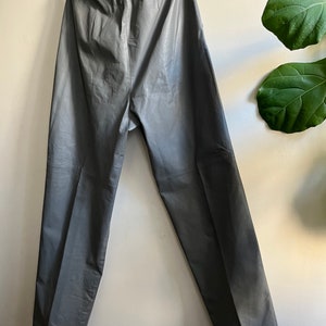May include: Gray leather pants with a straight leg and a high waist.